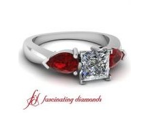 This stunning and elegant engagement ring reflects beauty and brilliance. An exquisite engagement ring consist of a glitzy prong set Center diamond along with shimmering pear shape Ruby Diamonds prong held diamonds hugging the focal diamond from either si